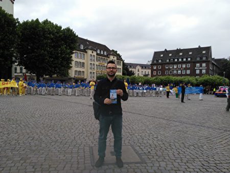 遊行隊伍到達城堡廣場，舉行集會演講。剛到德國才幾個月的27歲Hermin一直關注活動。他表示迫害很不好，反迫害活動應該一直舉辦，祝願中國好運。（祝蘭／大紀元）